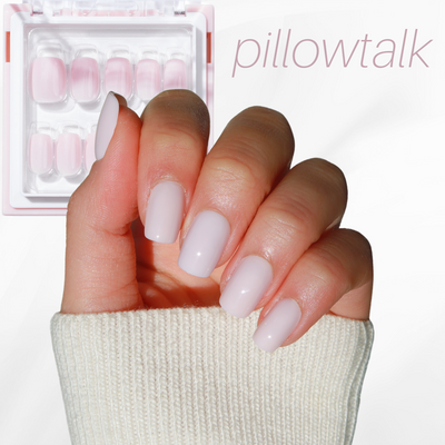A manicured hand with light pink, glossy nails stands out against a soft white background. In the upper left corner, a box from the Neutrals Lover Collection by Glowie By Her is prominently displayed, showcasing milky ombre nails. The word "pillowtalk" is elegantly inscribed in light pink in the upper right corner.
